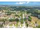 Aerial view of a residential neighborhood with tree-lined streets and a glimpse of a lake at 905 Hatteras Ave, Minneola, FL 34715