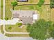 Top-down aerial view of a home with a spacious driveway, manicured lawn, and mature trees at 905 Hatteras Ave, Minneola, FL 34715
