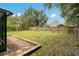 Large backyard with a privacy fence, mature landscaping, and a stone pathway at 905 Hatteras Ave, Minneola, FL 34715