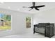 Modern bedroom with a ceiling fan, a crib, and two windows that provide great views at 905 Hatteras Ave, Minneola, FL 34715
