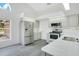 Bright kitchen features stainless steel appliances, white cabinets, and a window overlooking the front yard at 905 Hatteras Ave, Minneola, FL 34715