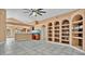 Spacious living room with a high ceiling, tile floor, and built-in shelving at 905 Hatteras Ave, Minneola, FL 34715