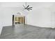 Spacious living room featuring modern ceiling fan, sliding doors to screened patio and gray laminate flooring at 905 Hatteras Ave, Minneola, FL 34715