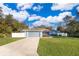 Cute blue house with a gray garage and a spacious lawn at 4089 Sw 133Rd Loop, Ocala, FL 34473