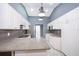 Modern kitchen with white cabinets, gray backsplash, and pendant lights at 4089 Sw 133Rd Loop, Ocala, FL 34473