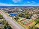 Expansive aerial view showcasing the neighborhood's pond, tennis courts, and tree-lined streets at 10812 Woodchase Cir, Orlando, FL 32836