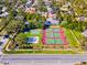 Aerial view featuring community amenities including tennis and basketball courts with lush landscaping at 10812 Woodchase Cir, Orlando, FL 32836