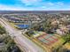 Neighborhood aerial view features tennis courts, community pond with fountain and beautiful Florida landscaping at 10812 Woodchase Cir, Orlando, FL 32836