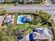 Aerial view of a home with a swimming pool, manicured lawns, and mature trees at 10812 Woodchase Cir, Orlando, FL 32836