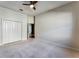 Bedroom featuring neutral walls, carpeting, double closet, and a ceiling fan at 10812 Woodchase Cir, Orlando, FL 32836