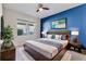 Comfortable bedroom featuring a king-size bed, blue accent wall, and modern furnishings at 10812 Woodchase Cir, Orlando, FL 32836