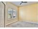Bedroom with carpeting, ceiling fan, shutters, and light yellow accent wall at 10812 Woodchase Cir, Orlando, FL 32836