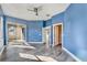 Bright bedroom featuring modern gray flooring, blue walls, ceiling fan, and sliding glass doors to a patio at 10812 Woodchase Cir, Orlando, FL 32836