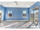 Bright bedroom with blue walls, wood-look flooring, and sliding glass doors at 10812 Woodchase Cir, Orlando, FL 32836