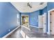 Bright bedroom with blue accent wall, gray flooring, a ceiling fan, and sliding glass doors to the screened in patio at 10812 Woodchase Cir, Orlando, FL 32836