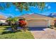 Charming home exterior with a well-manicured lawn, vibrant plants, and a paved driveway at 10812 Woodchase Cir, Orlando, FL 32836