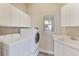 Laundry room with washer, dryer, cabinets, and utility sink at 10812 Woodchase Cir, Orlando, FL 32836