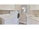 Bright laundry room with modern washer and dryer units, sink, and ample storage space at 10812 Woodchase Cir, Orlando, FL 32836