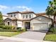 Charming two-story home with a stone facade, red tile roof, paver driveway, and manicured landscaping at 10875 Savona Way, Orlando, FL 32827