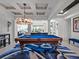 Game room boasting a pool table, modern chandelier, and access to backyard at 10875 Savona Way, Orlando, FL 32827