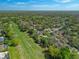 Expansive aerial shot of a verdant neighborhood bordering a golf course, dotted with mature trees at 123 Golf Club Dr, Longwood, FL 32779