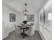 Cozy dining area featuring a modern light fixture, a black glass table, and a large window at 123 Golf Club Dr, Longwood, FL 32779