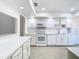 Updated kitchen boasts white cabinets, quartz countertops, and modern appliances at 123 Golf Club Dr, Longwood, FL 32779