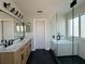 Modern bathroom featuring double vanity, sleek fixtures, and stylish glass-enclosed tub and shower at 13124 Oulton Cir, Orlando, FL 32832