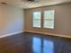 Bright bedroom features hardwood floors, neutral walls, and two large windows offering ample natural light at 13124 Oulton Cir, Orlando, FL 32832