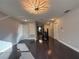 Open hallway featuring hardwood floors, grey walls, white doors, and a striking modern light fixture at 13124 Oulton Cir, Orlando, FL 32832