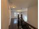 Hallway with dark wood floors and ornate banister leading to bedroom and living spaces at 13124 Oulton Cir, Orlando, FL 32832