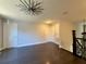 Open hallway featuring hardwood floors, gray walls, white doors, and a striking modern light fixture at 13124 Oulton Cir, Orlando, FL 32832