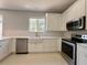 Charming kitchen with white cabinetry and stainless steel appliances at 13124 Oulton Cir, Orlando, FL 32832