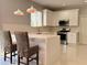 Well-lit modern kitchen featuring white cabinetry, stainless steel appliances, and bar stool seating at 13124 Oulton Cir, Orlando, FL 32832