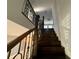 Dark wood staircase with decorative iron railing and banister lead to the second floor with natural light at 13124 Oulton Cir, Orlando, FL 32832