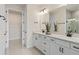 Double vanity bathroom with white cabinets, quartz countertops, and a large mirror at 13563 Pearl Beach St, Winter Garden, FL 34787