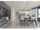 Modern dining room with marble table and gray chairs, open to the kitchen at 13563 Pearl Beach St, Winter Garden, FL 34787