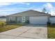 One-story house with a gray exterior, attached garage, and a well-maintained lawn at 139 Violet Ct, Kissimmee, FL 34759