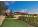 Landscaped backyard with fence and view of house at dusk at 1401 Lone Feather Trl, Winter Park, FL 32792