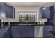 Modern kitchen with dark blue cabinets and a granite countertop at 14531 Damai Ln, Orlando, FL 32821