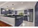 Modern kitchen with dark blue cabinets, granite counters, and stainless steel appliances at 14531 Damai Ln, Orlando, FL 32821