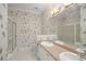 Bathroom with double sinks, shower, and floral wallpaper at 1522 Lake Knowles Cir, Winter Park, FL 32789