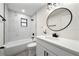 Modern bathroom with marble tile, white vanity, and black fixtures at 1523 N Beach St, Ormond Beach, FL 32174