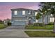 Two-story house with gray siding, gray garage door, and landscaping at 1533 Maidstone Ct, Champions Gate, FL 33896