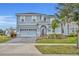 Two-story house with gray siding, paved driveway, and landscaping at 1533 Maidstone Ct, Champions Gate, FL 33896