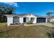 Newly constructed home with black garage door and well-manicured lawn at 1613 Lansfield Ave, Deltona, FL 32738