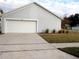 Attached garage with a white door and landscaping at 1621 Slash Pine Pl, Oviedo, FL 32765