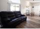 Relaxing living room featuring a black leather reclining sofa and wood-look floors at 1621 Slash Pine Pl, Oviedo, FL 32765