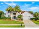 Two-story house with white exterior, palm trees, and landscaped yard at 1706 Tiverton St, Winter Springs, FL 32708