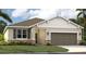 One-story home with brown-gray siding, stone accents, and a two-car garage at 1720 Columbus Path, St Cloud, FL 34771